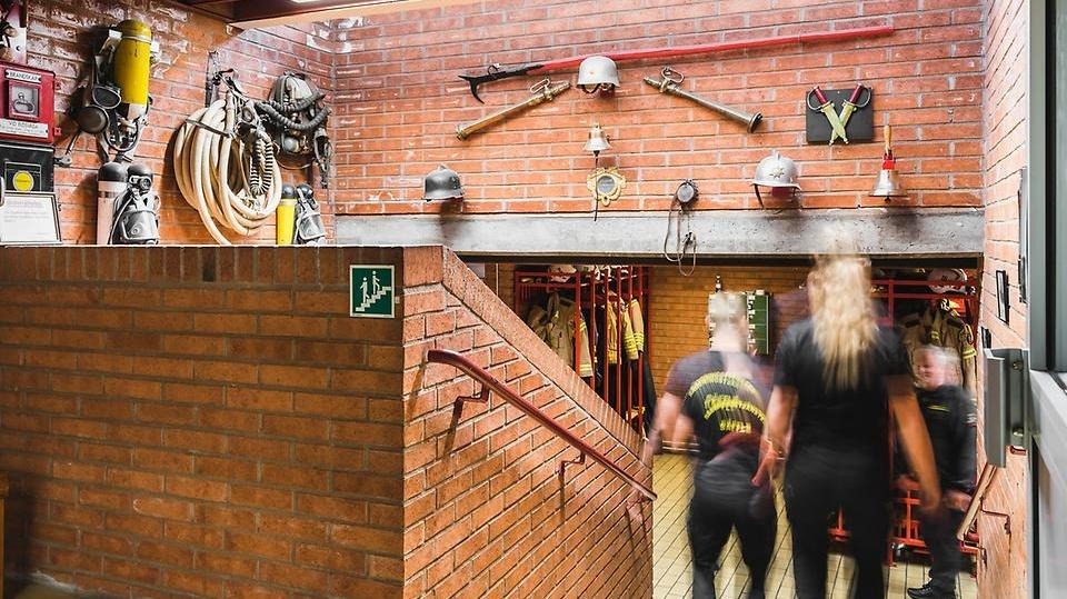Två medarbetare från Säffle räddningstjänst går nedför en trappa i Säffle brandstation
