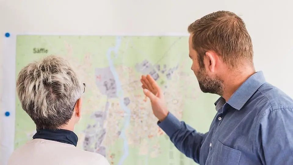 Två personer som står framför en karta och pratar